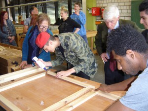 Ines Strehlau (l.) udn Harald Kämpf schauen den Jugendlichen bei der Arbeit in der Werkstatt über die Schultern.